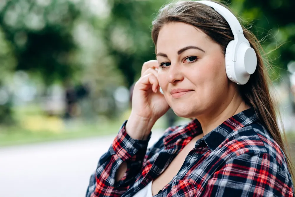 Femme qui écoute avec des écouteurs, ressources audio et écrites pour femmes autistes et TDAH
